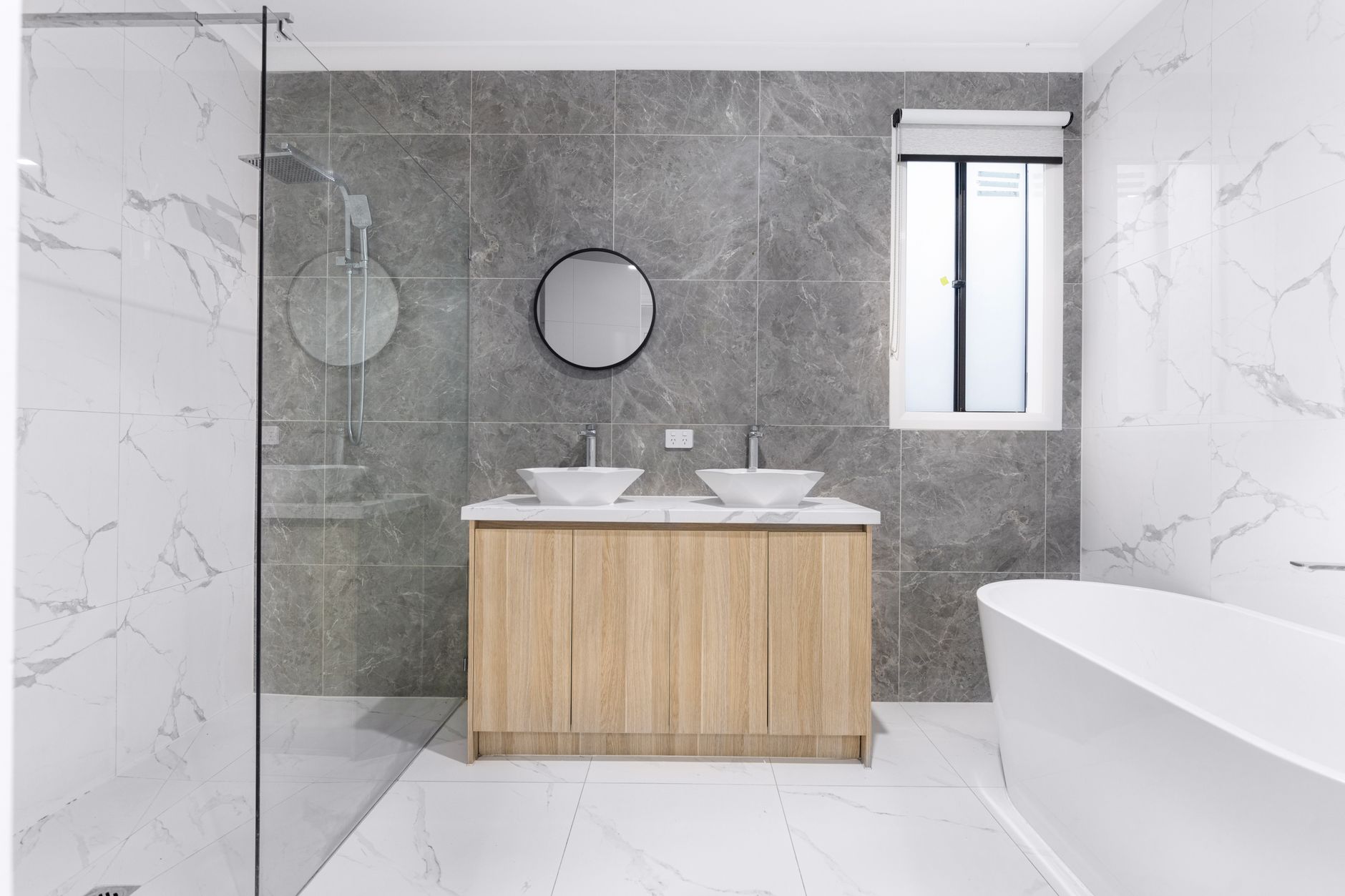 A finished tiled bathroom with a timber vanity